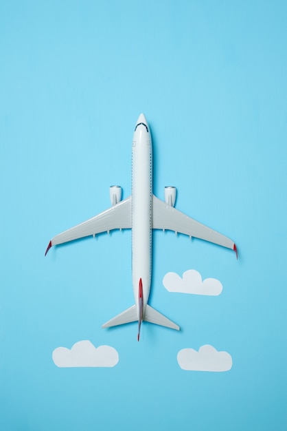 White airplane on a blue background with clouds