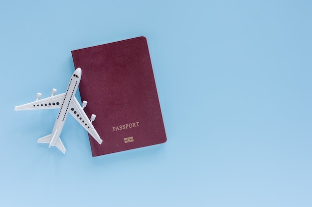 White airplane model with passport on blue for travel and journey concept