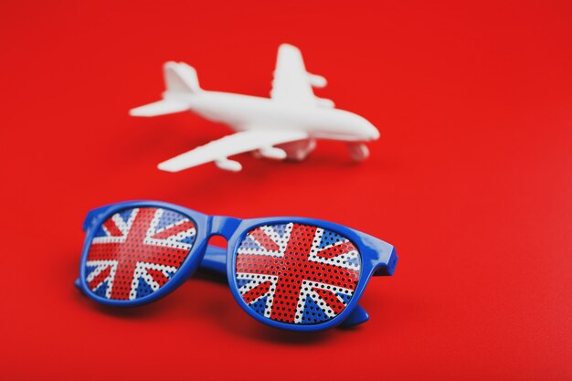 White airplane and sunglasses with the flag of the United Kingdom. Travel to England.