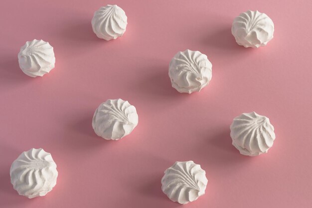 White airy sweet marshmallow on a pink background. Horizontal photo from above, background - food concept.