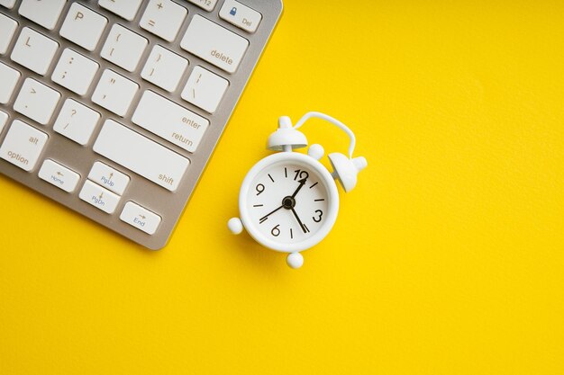 Photo white alarm clock and keyboard top view business deadline schedule and urgent tasks