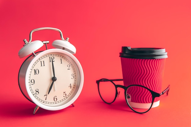 White alarm clock paper cup and glasses on Viva Magenta