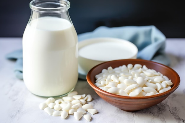 Foto mandorle bianche a bagno in una ciotola accanto a una bottiglia di latte di mandorla