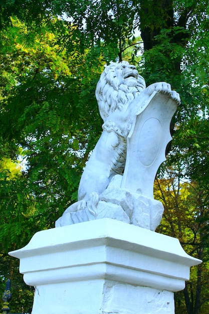 white ancient statue of lion on the base