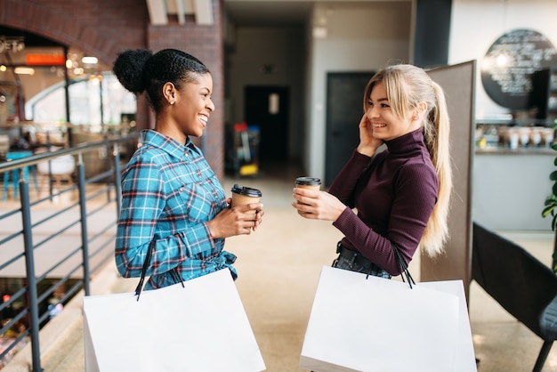 写真 モールで買い物袋を持つ白と黒の女性