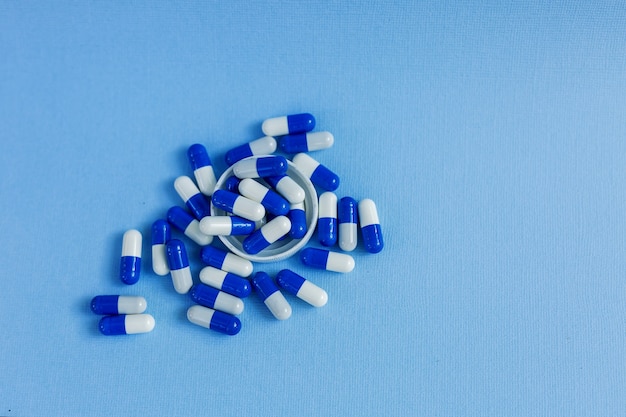 사진 타원형 모양의 흰색과 파란색 약 캡슐은 파란색 배경에 거짓말.