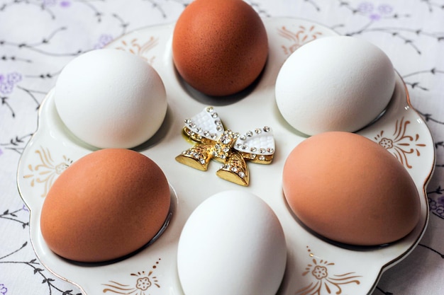 Фото Белые и коричневые яйца на специальной тарелке натурального цвета подготовка к пасхальной диете и здоровому питанию