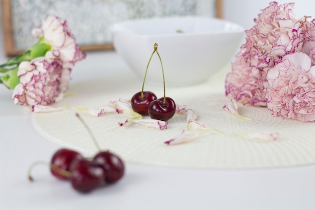 White angel on desk. beautiful pink flowers on white desk.