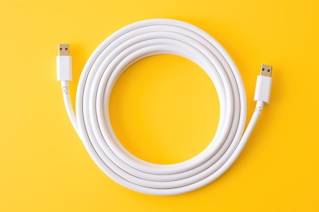 White Apple lightning to USB C cable coiled on yellow backdrop