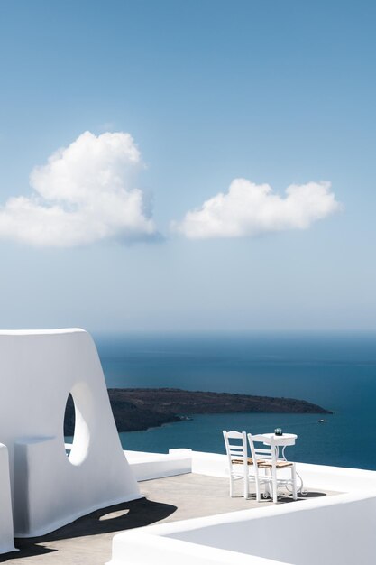 Foto architettura bianca nell'isola di santorini in grecia due sedie sulla terrazza con vista sul mare