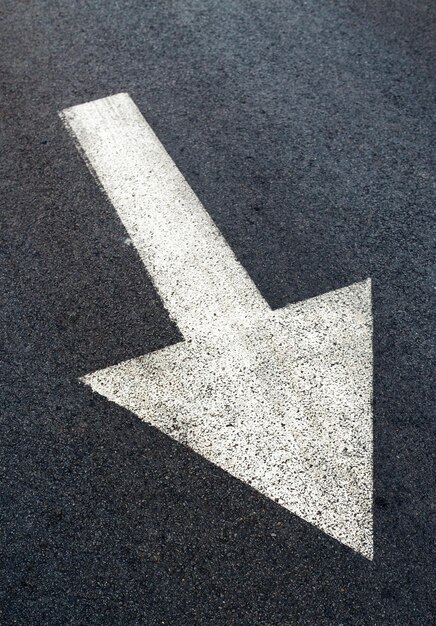 Photo white arrow on asphalt road traffic sign