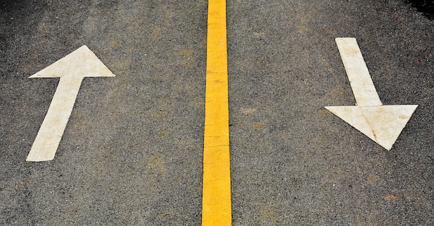 Photo white arrow painted on asphalt road