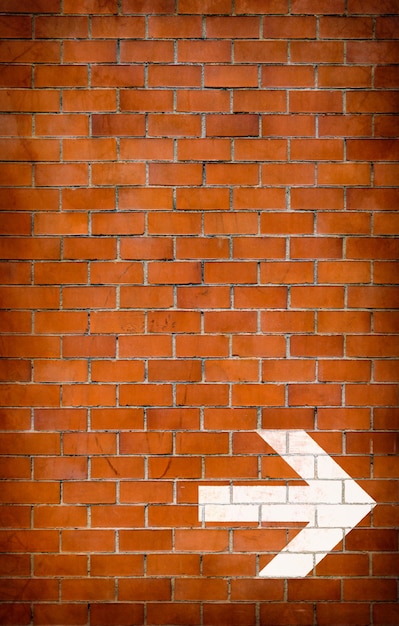 White arrow painted on brick wall