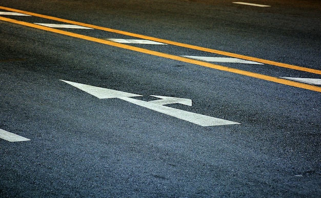 White arrow and turn right sign on black asphalt