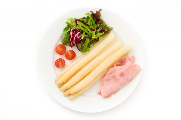 White asparagus with salad and ham on white