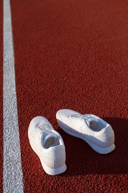 Scarpe da ginnastica atletiche bianche su un tapis roulant da stadio. concetti di sport, salute e benessere.