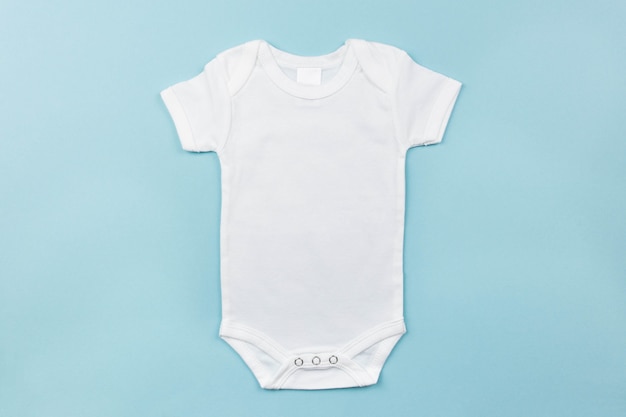 White baby boy bodysuit mockup flat lay on the pink surface