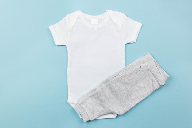 White baby boy bodysuit mockup flat lay with gray panties on the blue surface