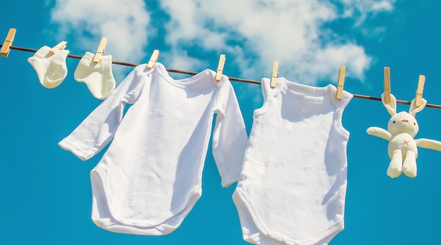 White baby clothes dry on a rope