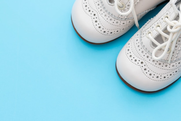 White baby shoes on blue background