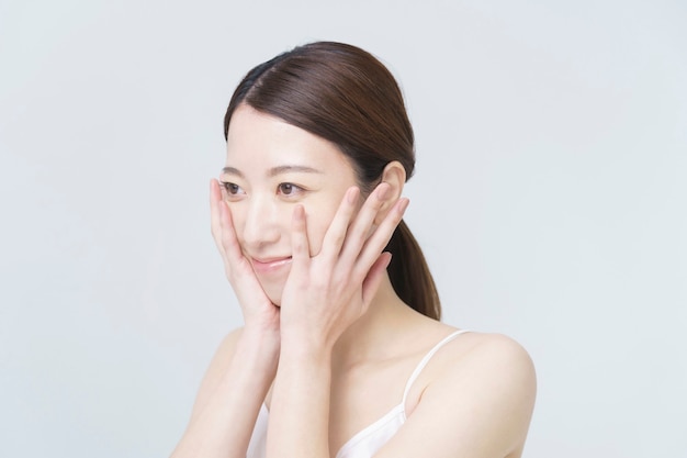 white back ground beauty image / asian woman touching her face