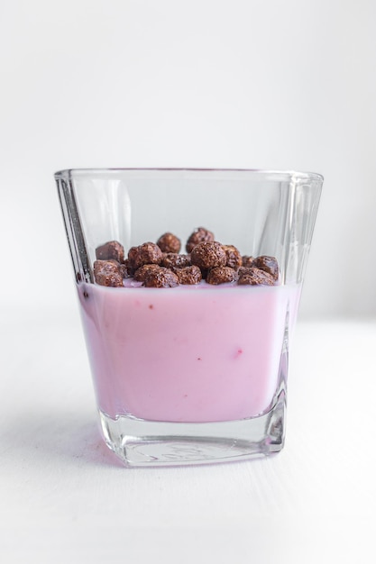 White background. Light breakfast. Yogurt with chocolate balls. Children's menu. Useful snack.