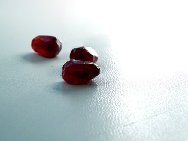 On a white background red pomegranate seeds