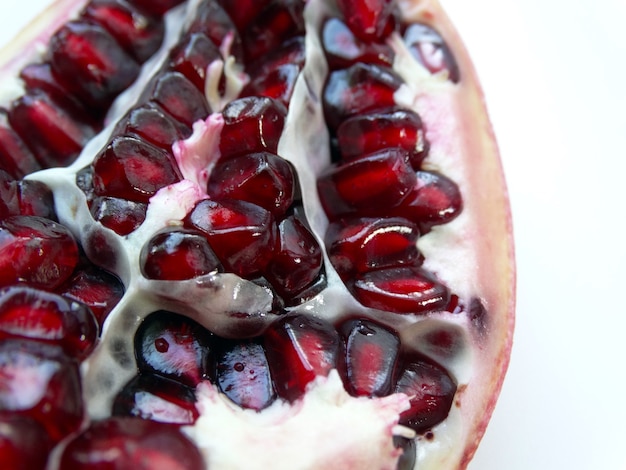 On a white background red pomegranate seeds