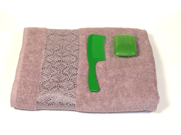 On a white background a towel with a comb and soap
