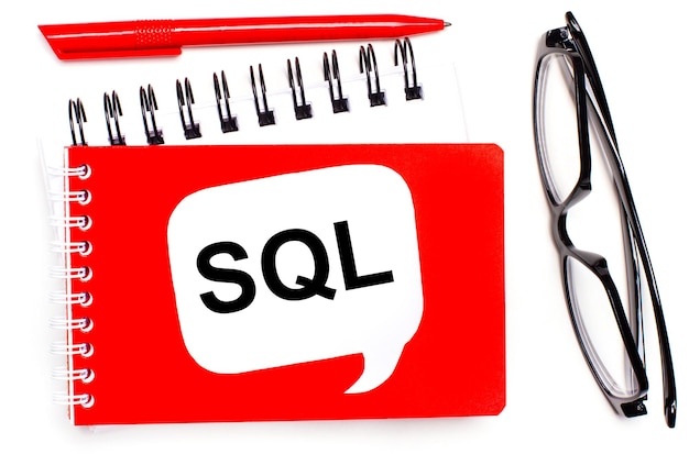 흰색 배경에 흰색 및 빨간색 메모장 검정색 안경에 빨간색 펜과 SQL Structured Query Language 텍스트가 있는 흰색 카드