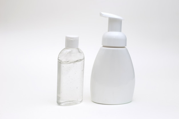 White background with a white bottle of antibacterial soap and bottle antibacterial gel for hands