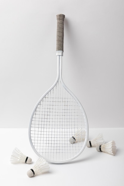 Photo white badminton shuttlecocks scattered near racket on white background