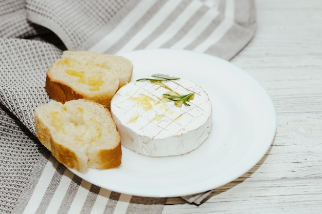 White baguette cut into pieces with olive oil and Camembert cheese on the table