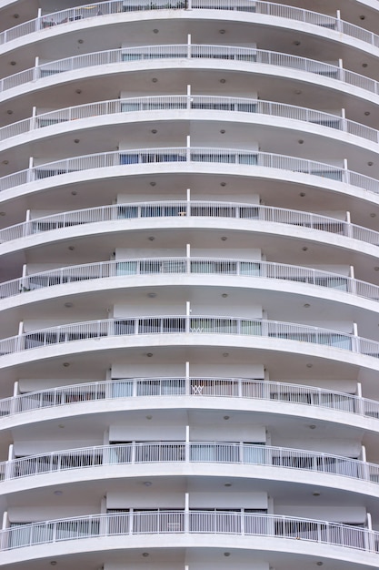 White balcony of building exterior a modern circular of and glass windows.