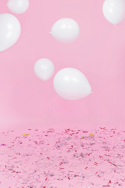 ピンクの背景に対する紙吹雪上の空気中の白い風船