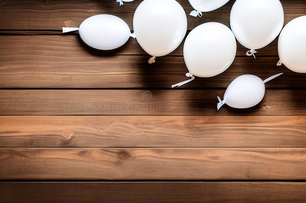 White balloons on a wooden table with a string tied to the top.