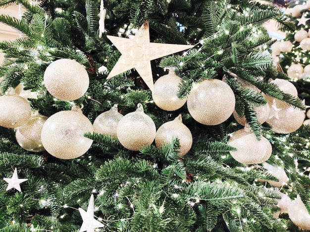 White balls and stars decorate Christmas tree in closeup