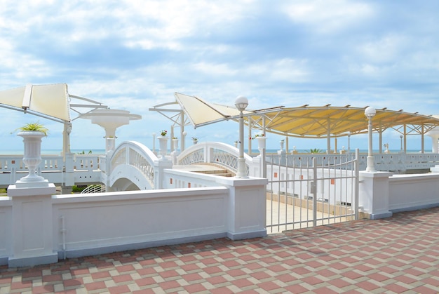 White balustrade of the embankment at the beach under the blue sky