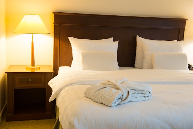 Photo white bathrobe on the bed in the bedroom of the hotel room