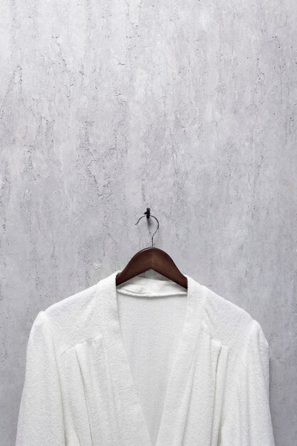 Photo white bathrobe on a gray wall in loft style.