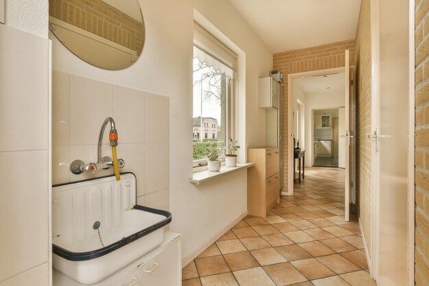 a white bathroom with a sink and a window