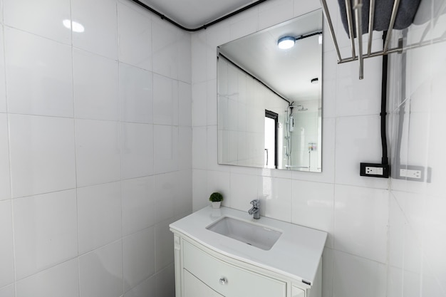 White bathroom with washbasin faucet and mirror