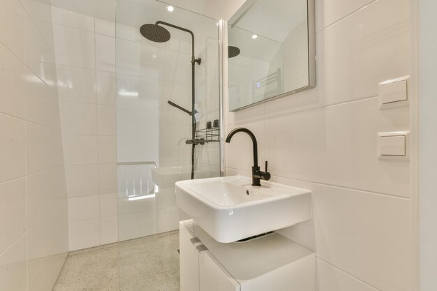 a white bathroom with a white sink and a shower