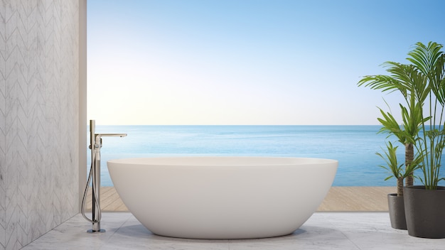 White bathtub on marble floor near terrace of infinity pool in modern beach house