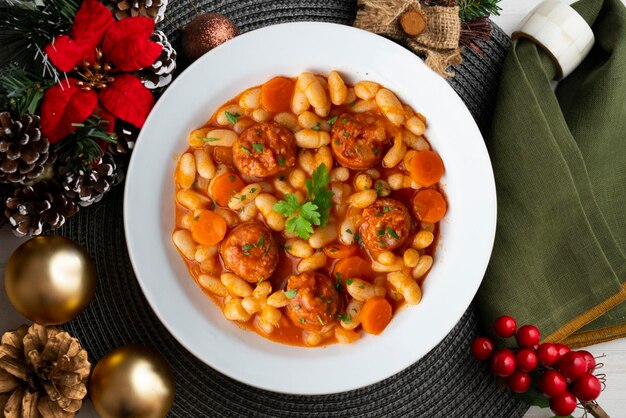 Photo white bean stew with chorizo on a table decorated with christmas elements