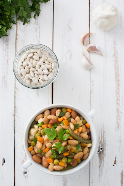 White beans with vegetables in a bowl top view