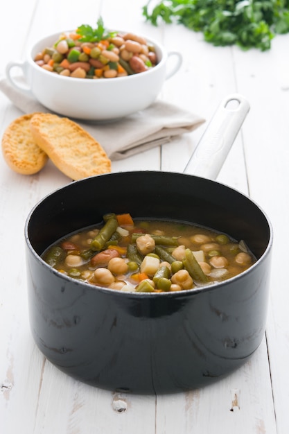 White beans with vegetables on white wooden table