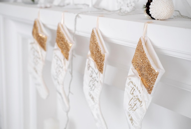 White beautiful Christmas socks hanging on fireplace