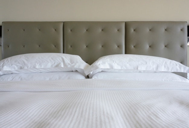 白いシーツと壁の背景に古典的なスタイルのグレー色のベッドの頭と枕