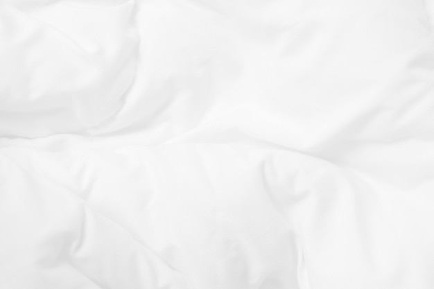 아침에 일어나면 침실에 하얀 침구 시트와 주름진 담요